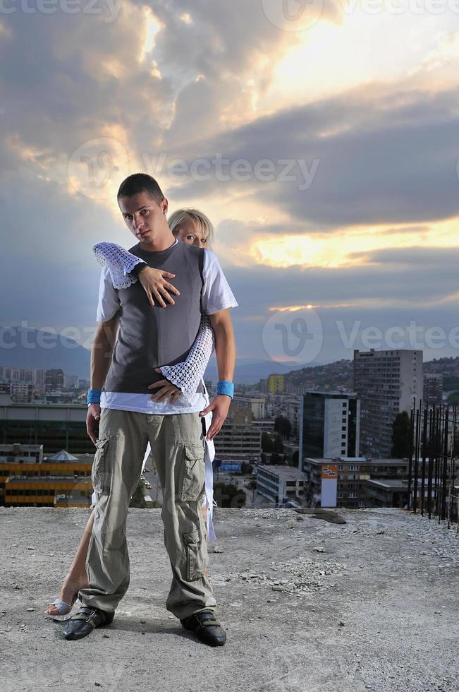 romantic urban couple dancing on top of  bulding photo
