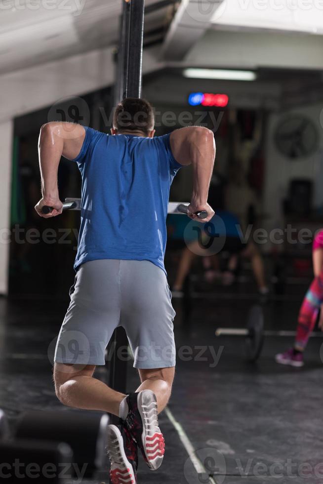 man doing exercises parallel bars photo