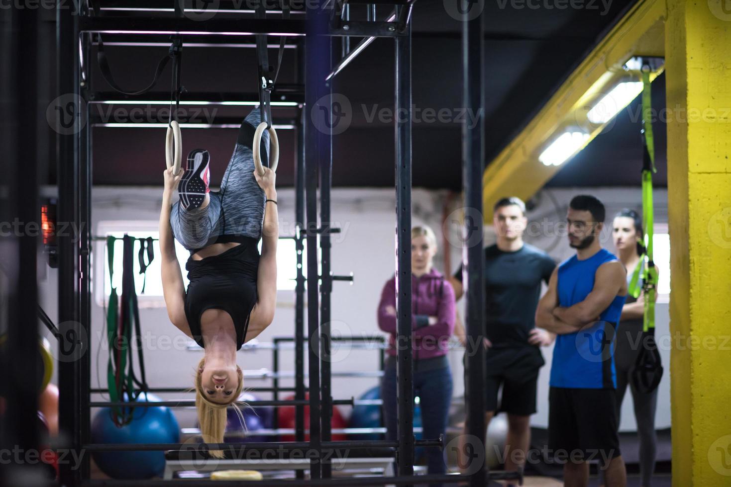 mujer trabajando con entrenador personal en anillos de gimnasia foto