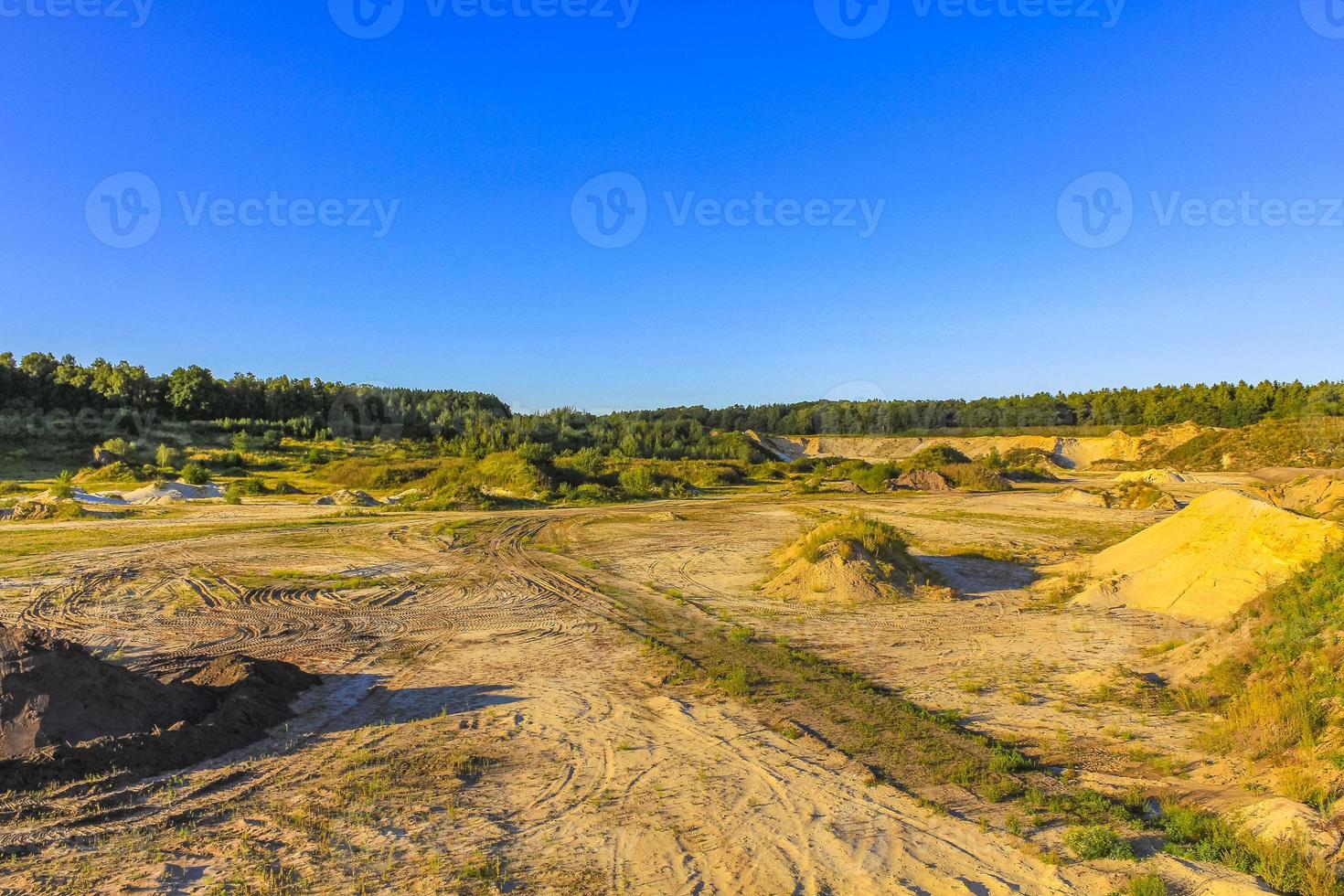 montañas de arena excavadas y pilas de escombros lago de cantera estanque de dragado. foto