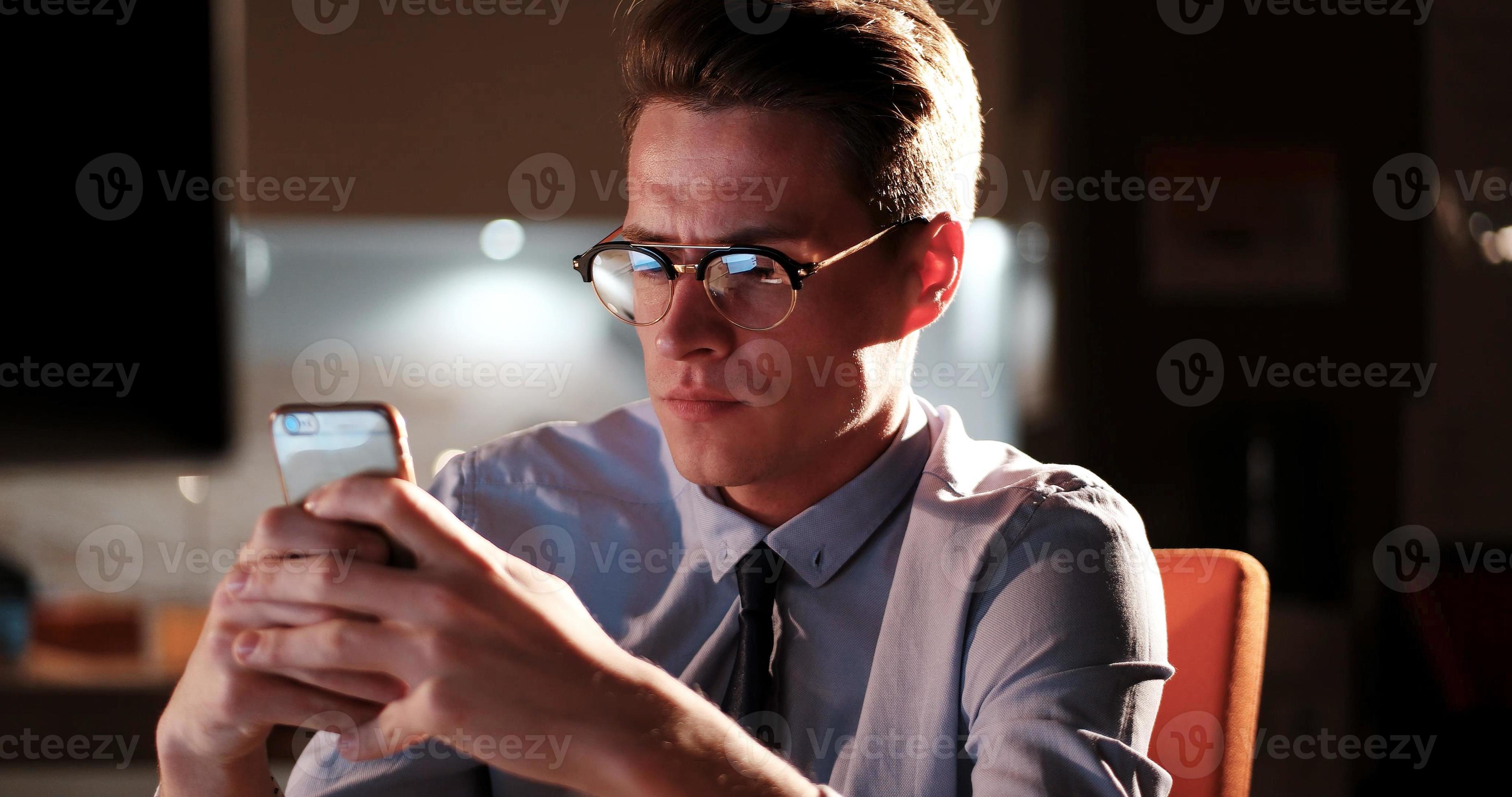 man using mobile phone in dark office 11303280 Stock Photo at Vecteezy