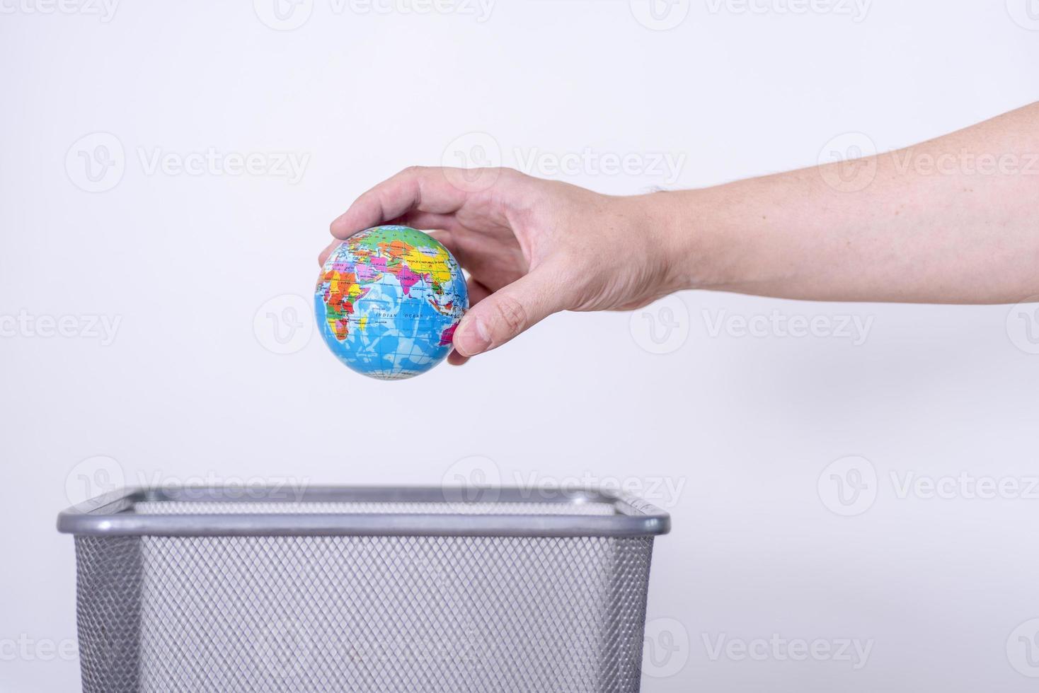 The globe is thrown in the trash garbage can. photo