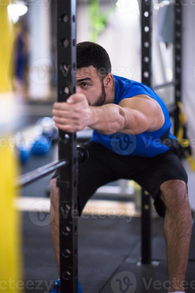man doing pull ups on the vertical bar photo