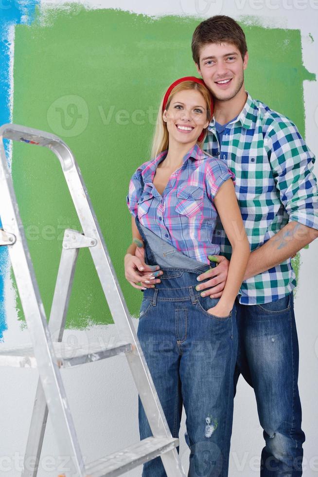 happy couple paint wall at new home photo