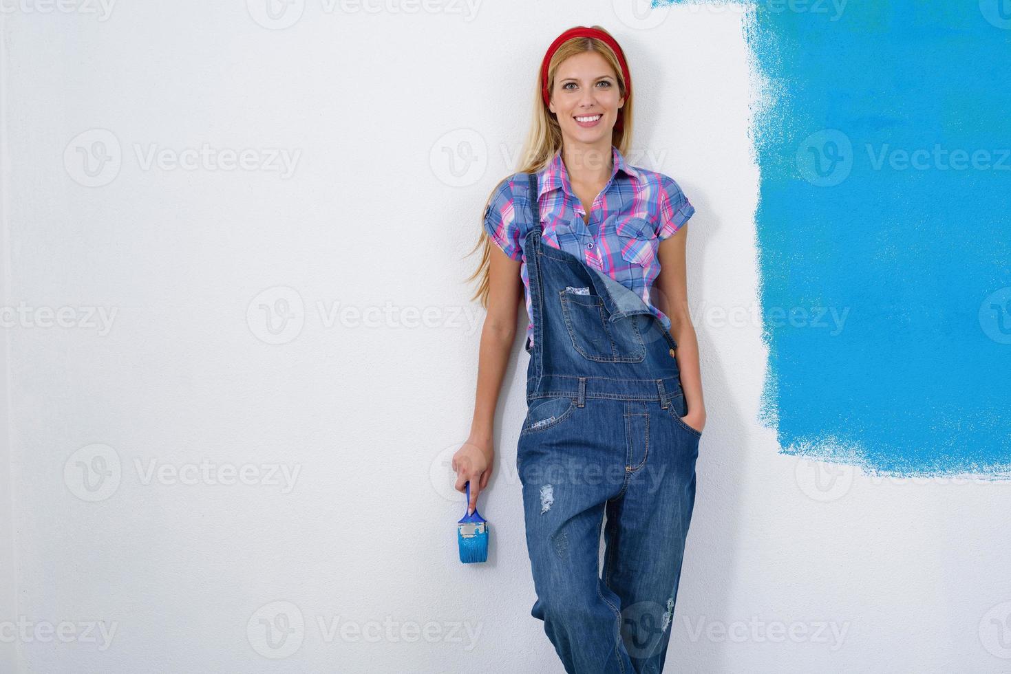 happy smiling woman painting interior of house photo