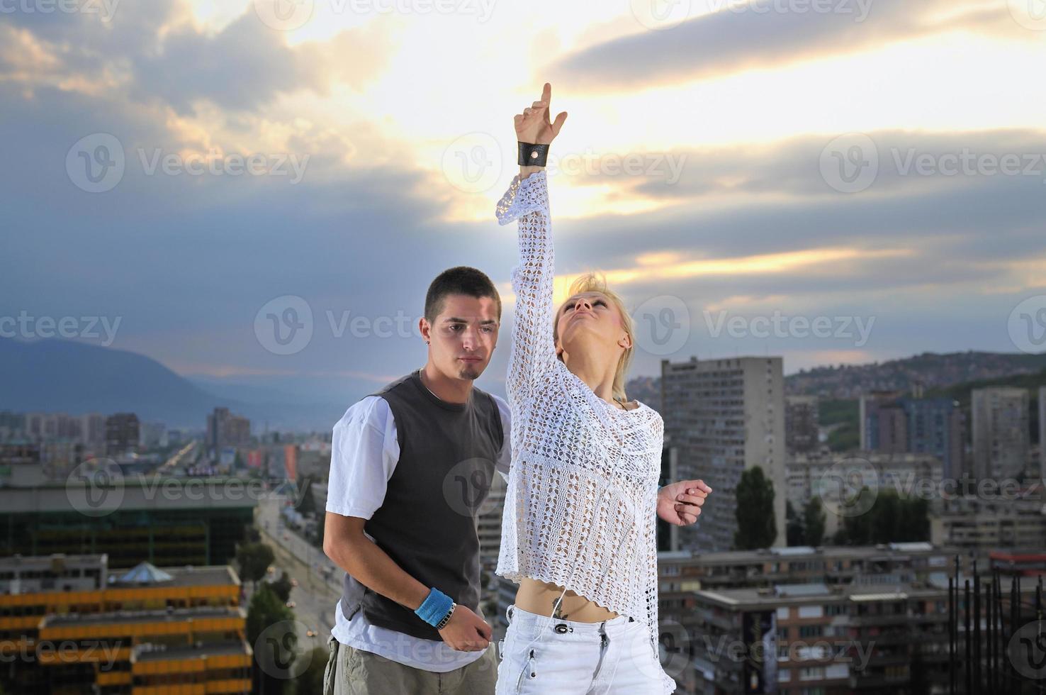 romantic urban couple dancing on top of  bulding photo