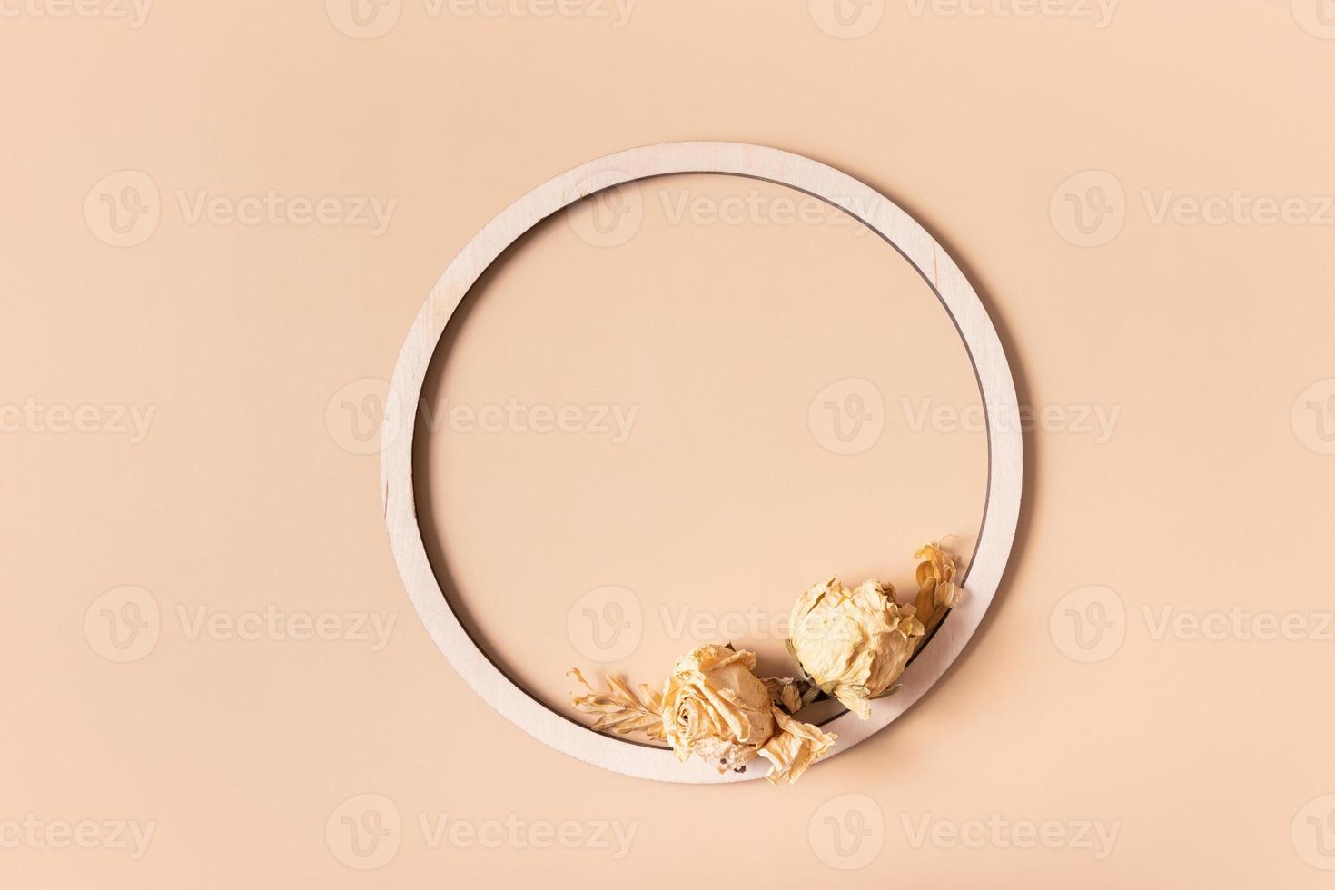 Autumn composition. Wooden ring and dried flowers on pastel beige background. Autumn, fall concept. Flat lay, top view, copy space. photo