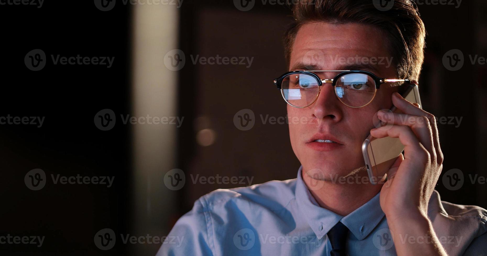 man using mobile phone in dark office photo