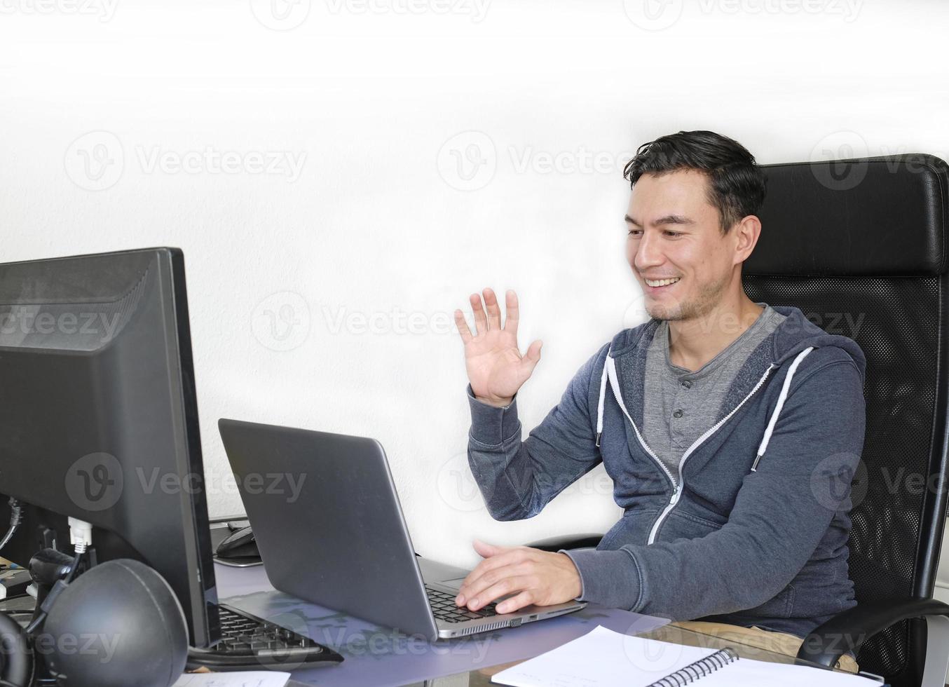Man in casual outfit working from home with a laptop in the living room photo