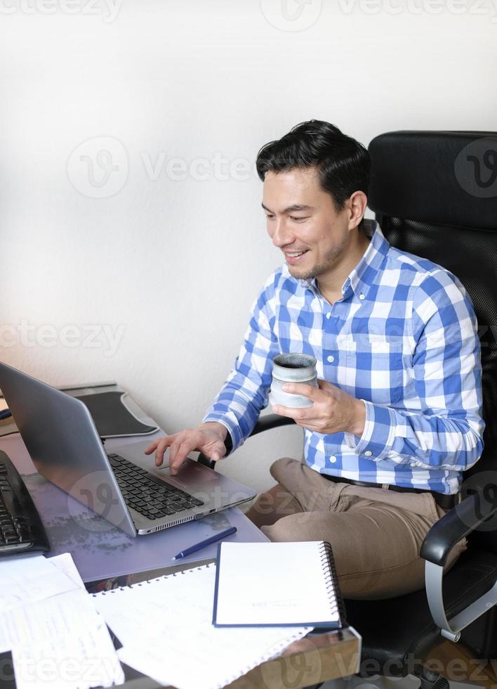 Man working from home with a laptop at the desk photo