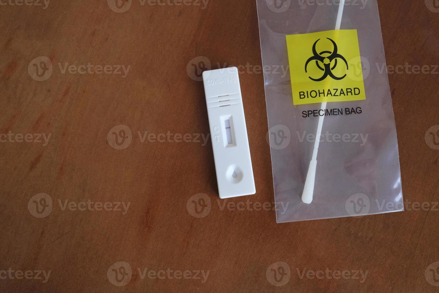 Coronavirus - COVID-19 - rapid test with negative result next to a nasal swab in a transparent bag with bio hazard photo