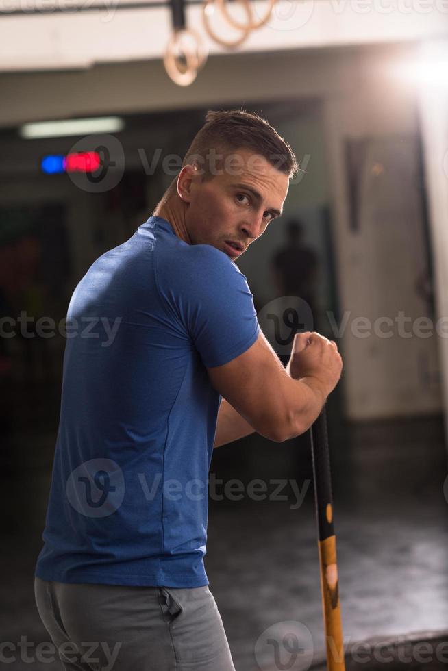 man workout with hammer and tractor tire photo