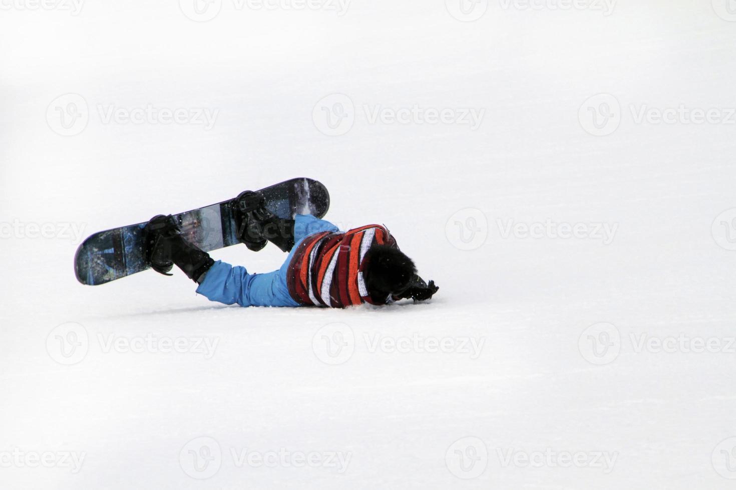 Snowboarder falling onto the floor photo