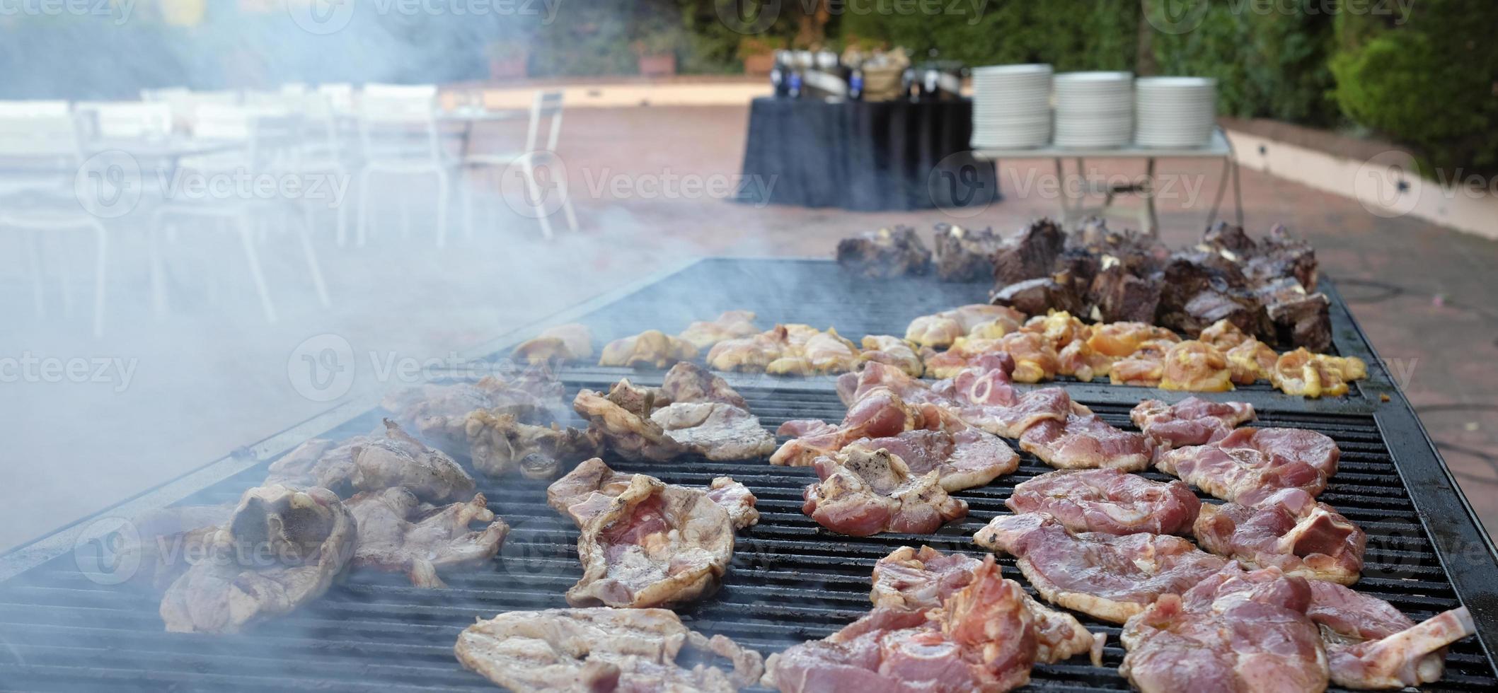 Smoking barbecue grill with numerous pieces of meat on it photo