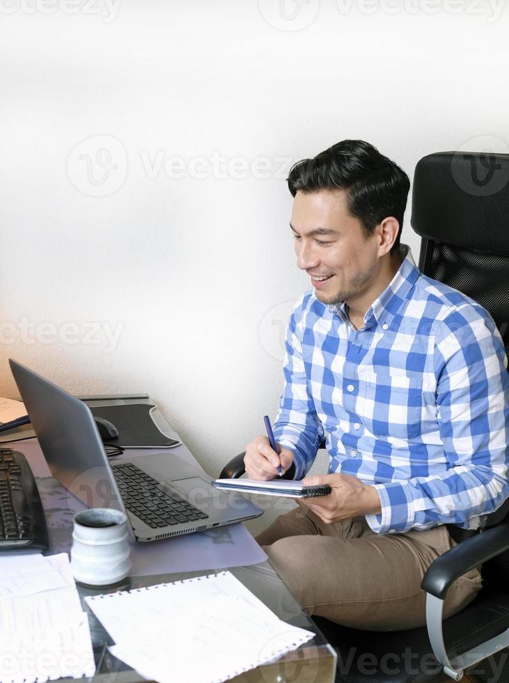 Man working from home with a laptop at the desk photo