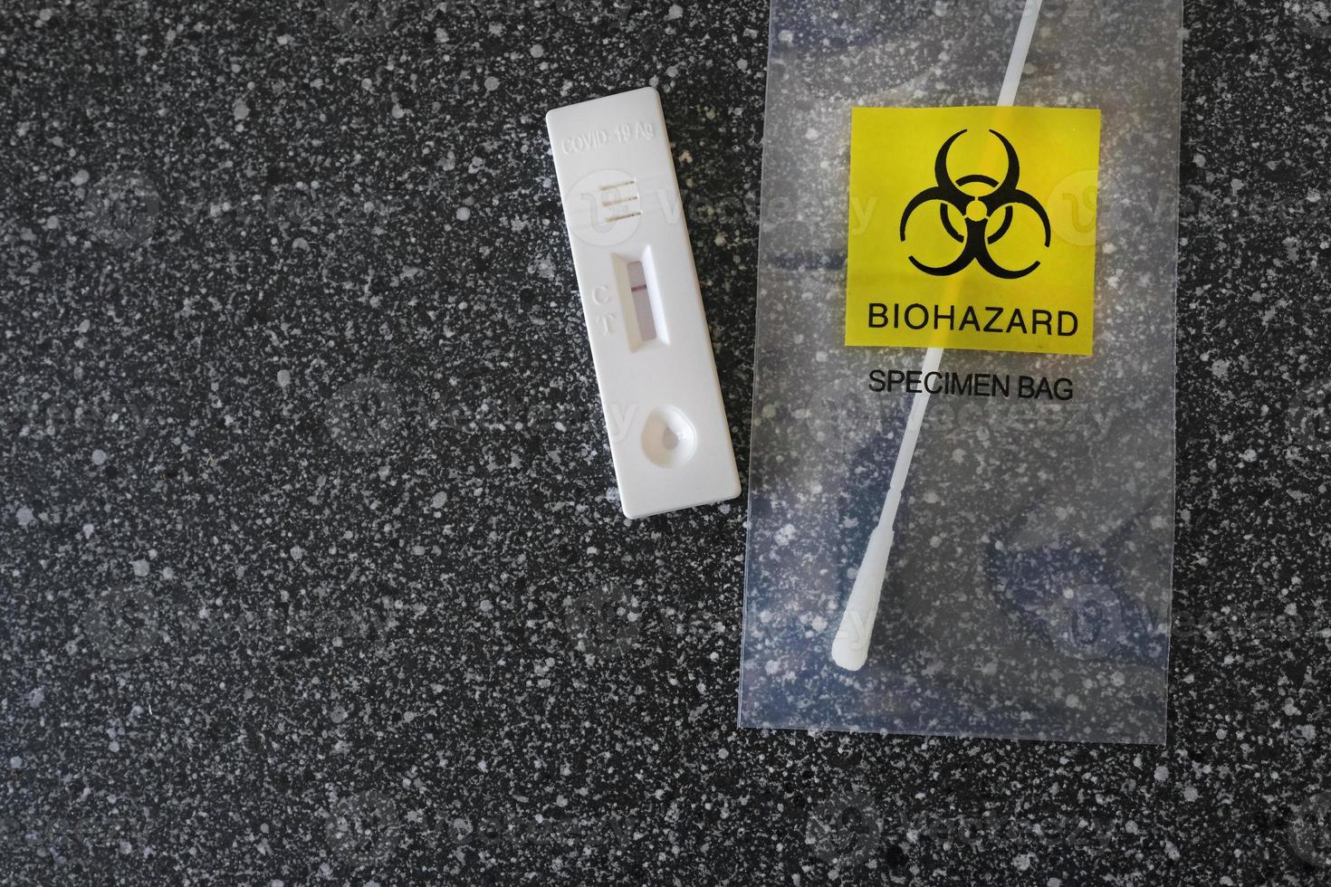 Coronavirus - COVID-19 - rapid test with negative result next to a nasal swab in a transparent bag with bio hazard photo