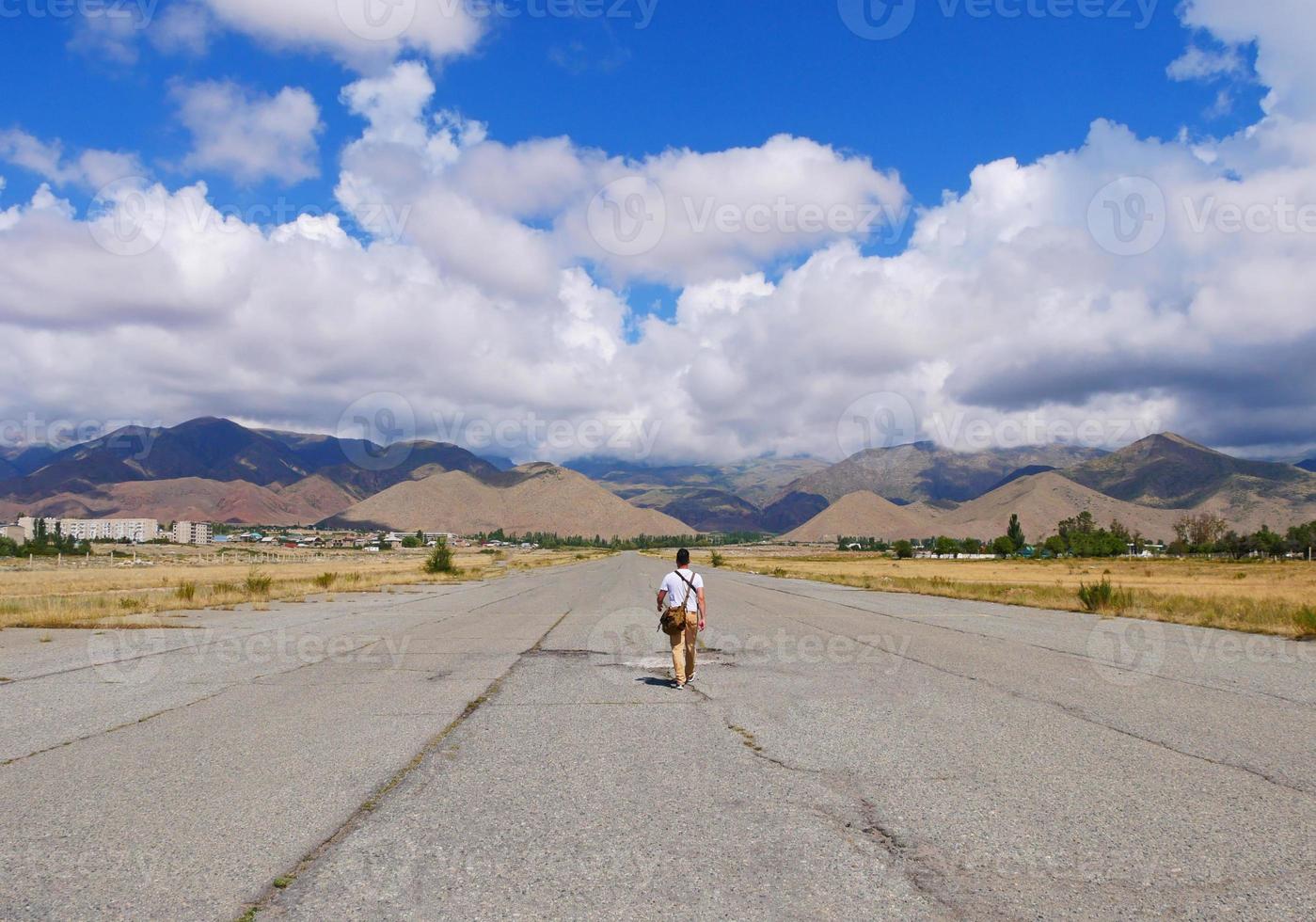 Man seen from the back as he walks on an abandoned airfield photo