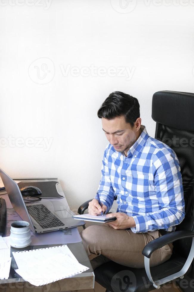 un hombre trabajando desde casa en un escritorio foto