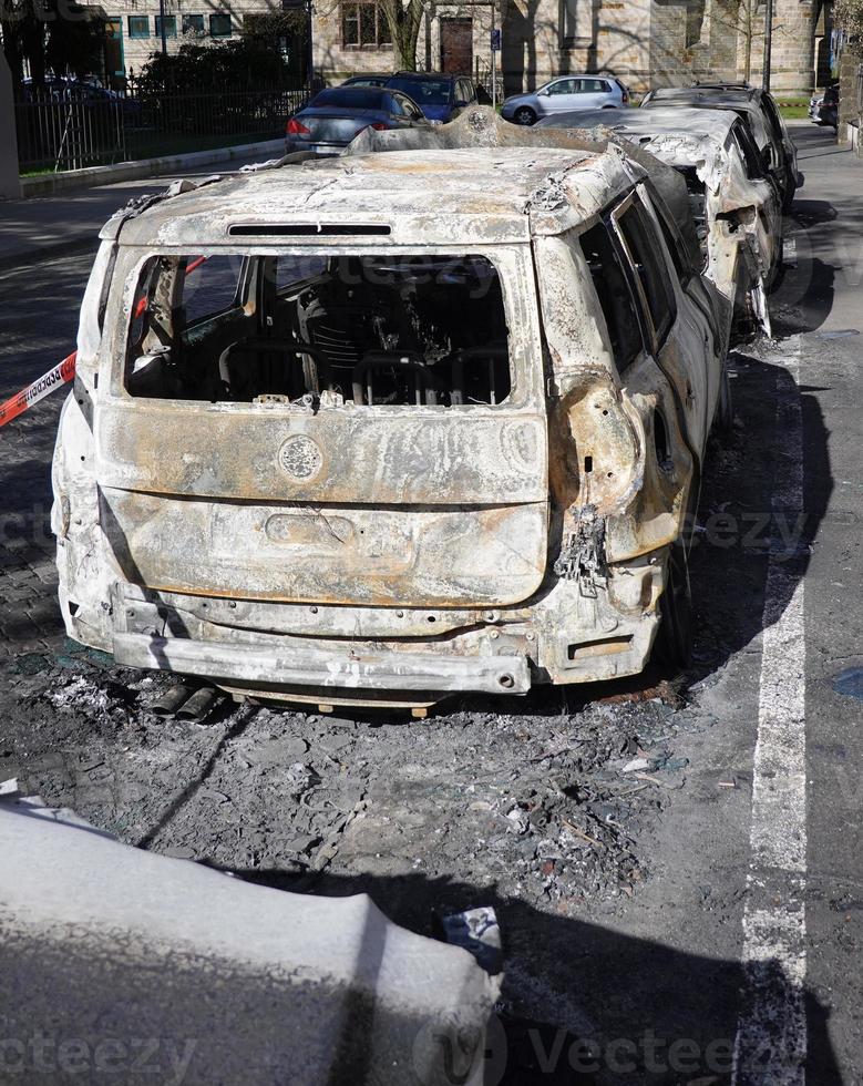 burned out gutted car wreck parked in residential street photo