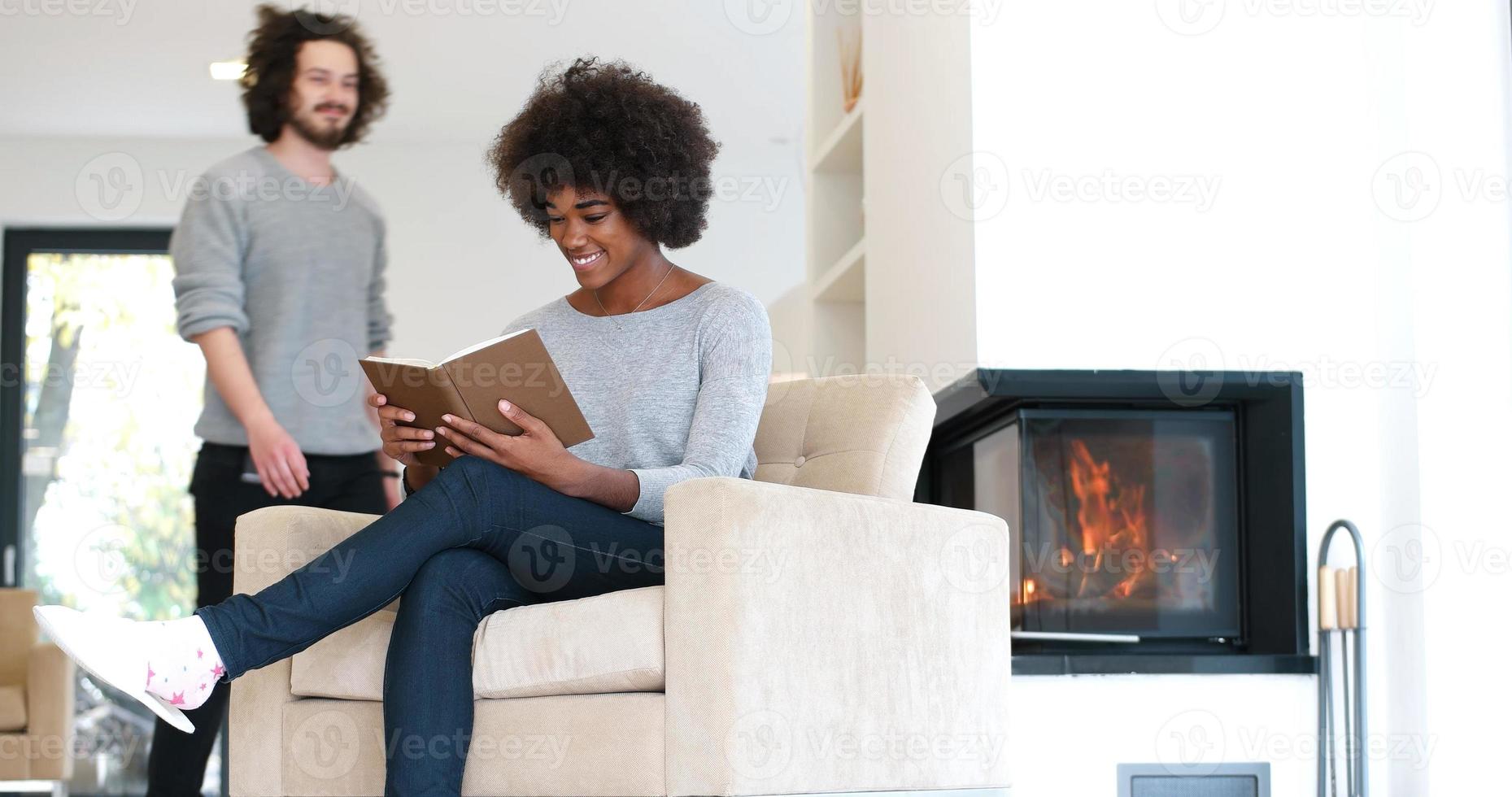 pareja multiétnica abrazándose frente a la chimenea foto