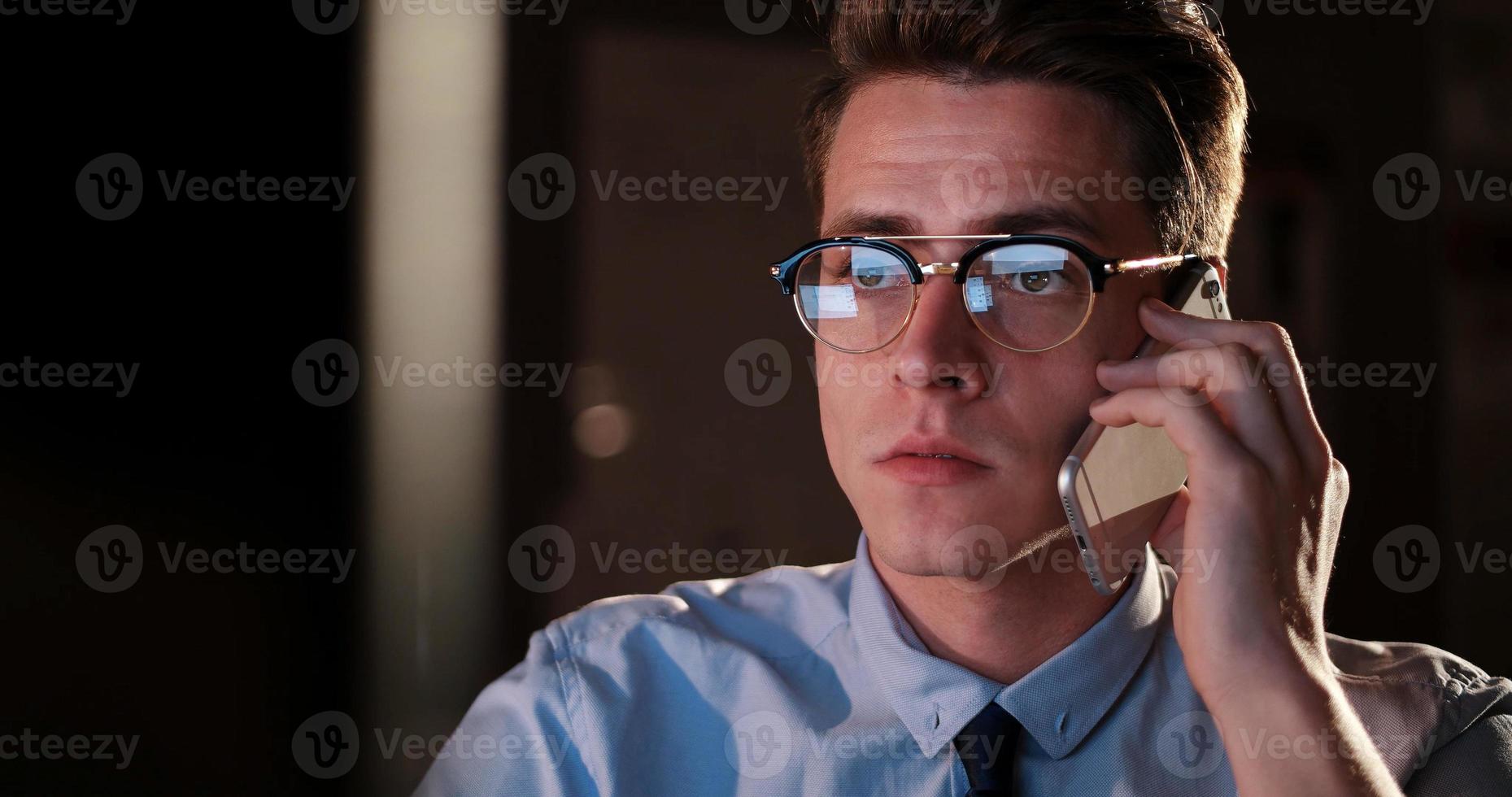man using mobile phone in dark office photo
