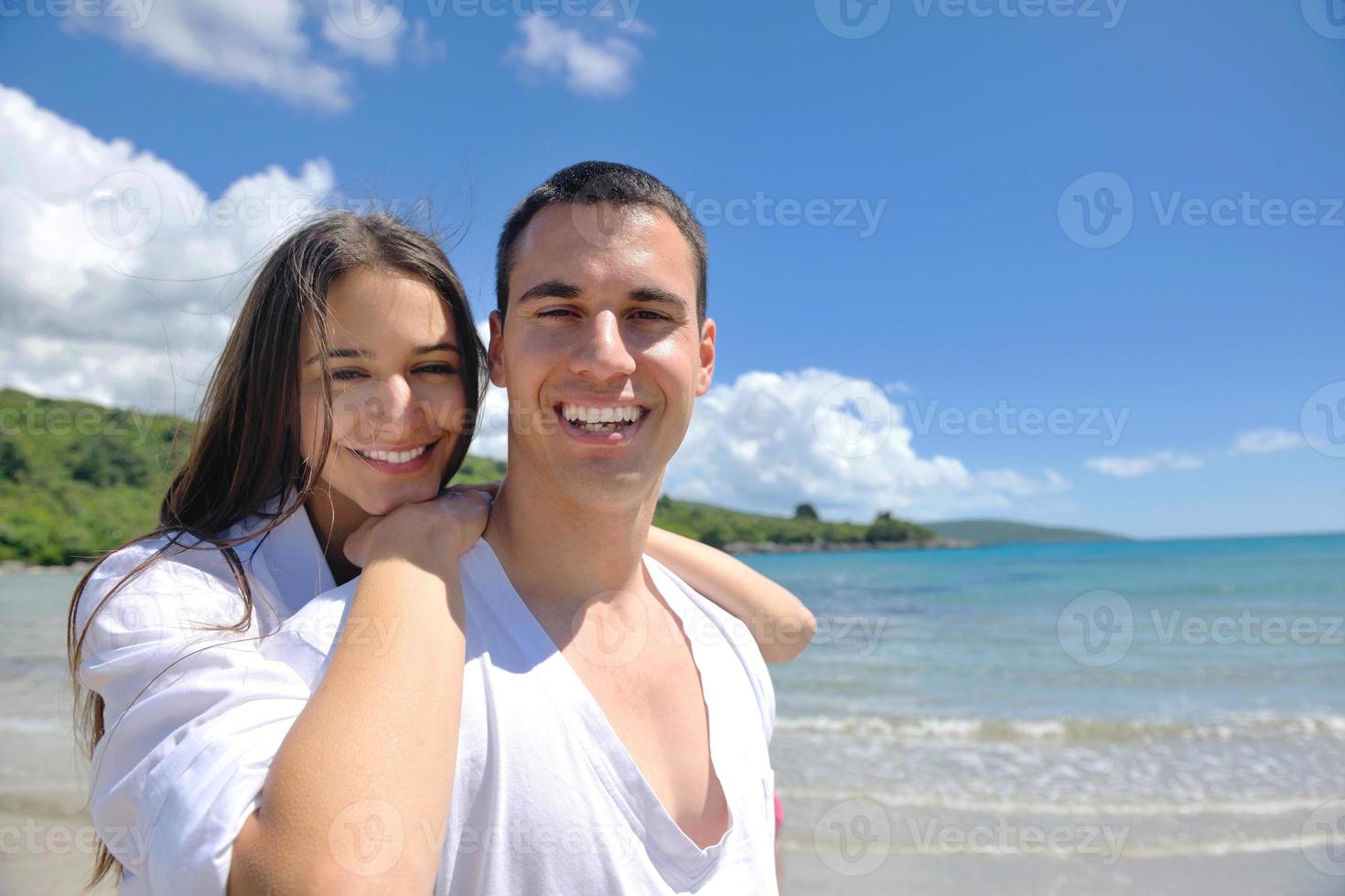 feliz pareja joven divertirse en la playa foto