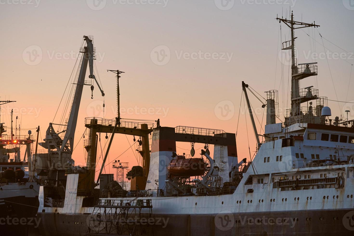 Ships in sea port on sunset background photo