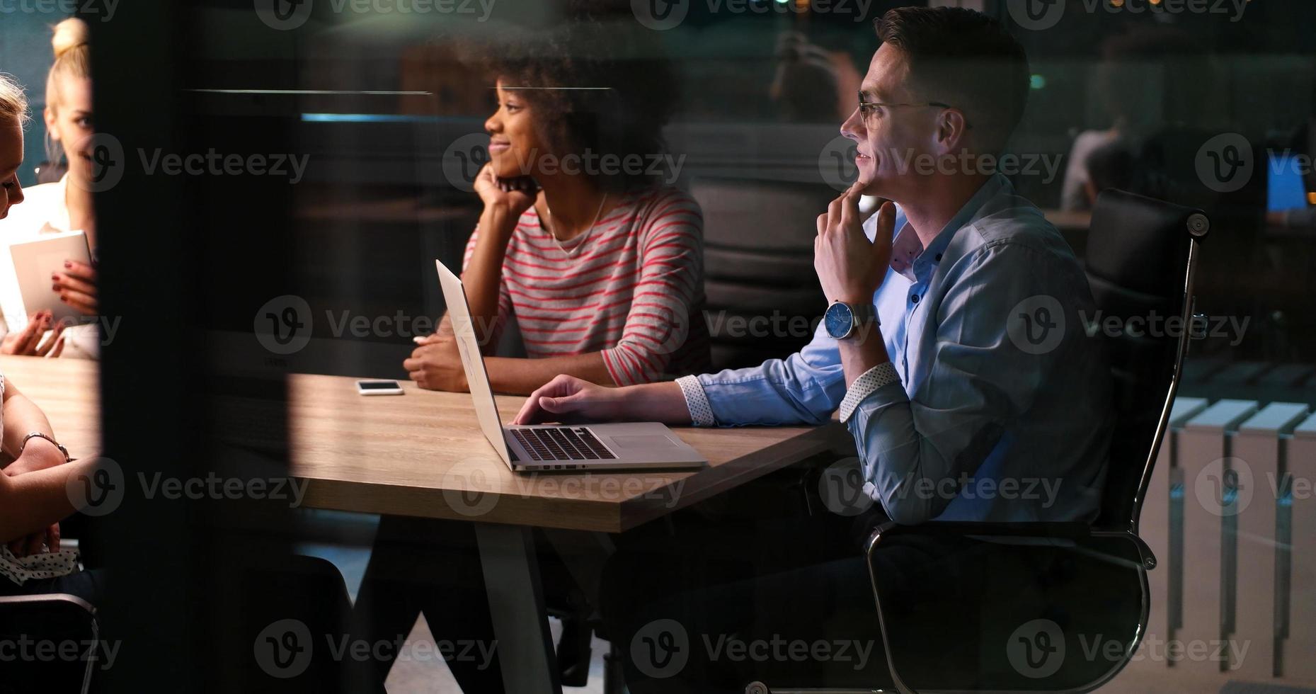 Multiethnic startup business team in night office photo