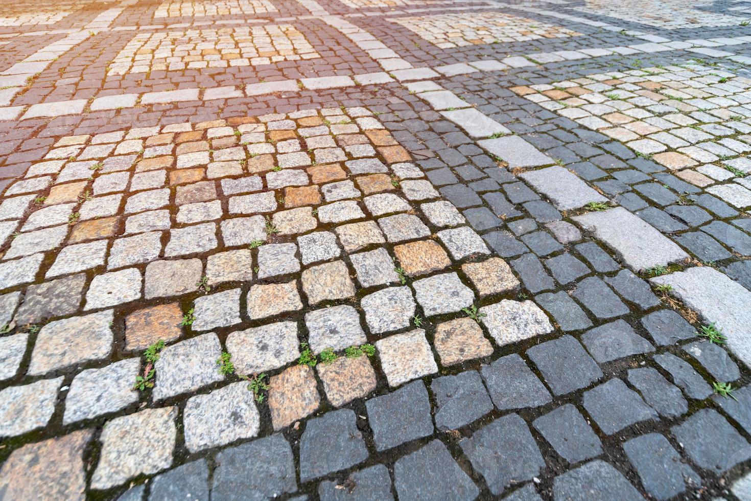 antiguo patrón de adoquines. textura de adoquines alemanes antiguos en el centro de la ciudad. pequeños azulejos de granito. pavimentos grises antiguos. foto