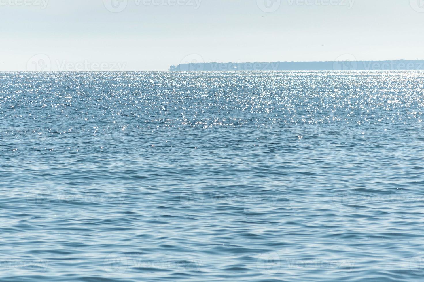 Sunny seascape. Part of the peninsula in the distance. Calm and good weather. No wind photo