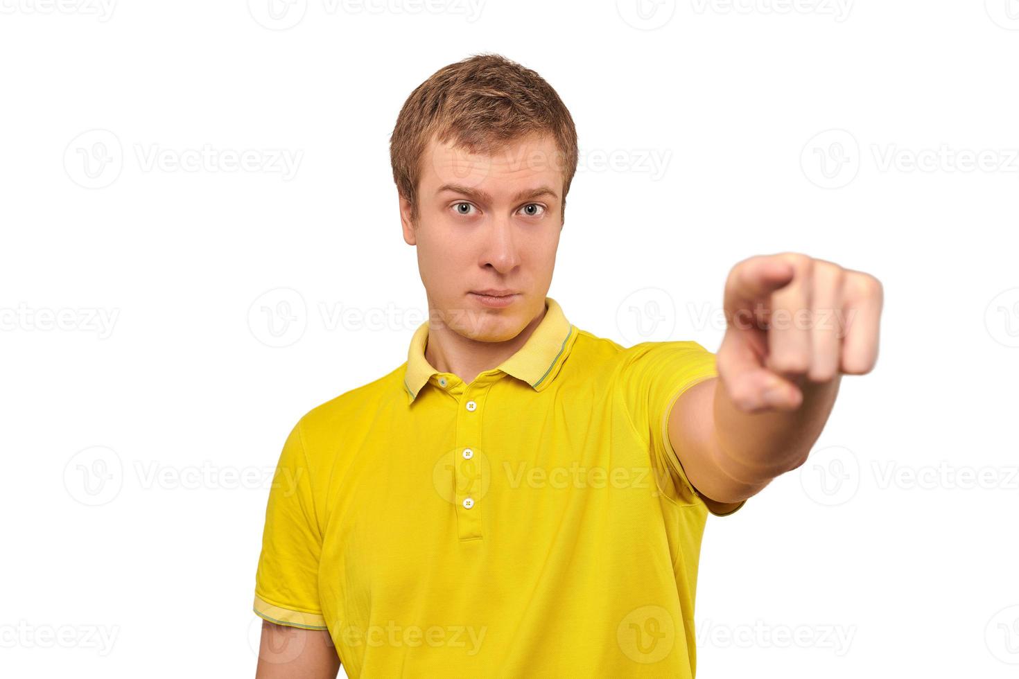 Nice handsome guy in casual yellow Polo T-shirt pointing forward isolated on white background photo