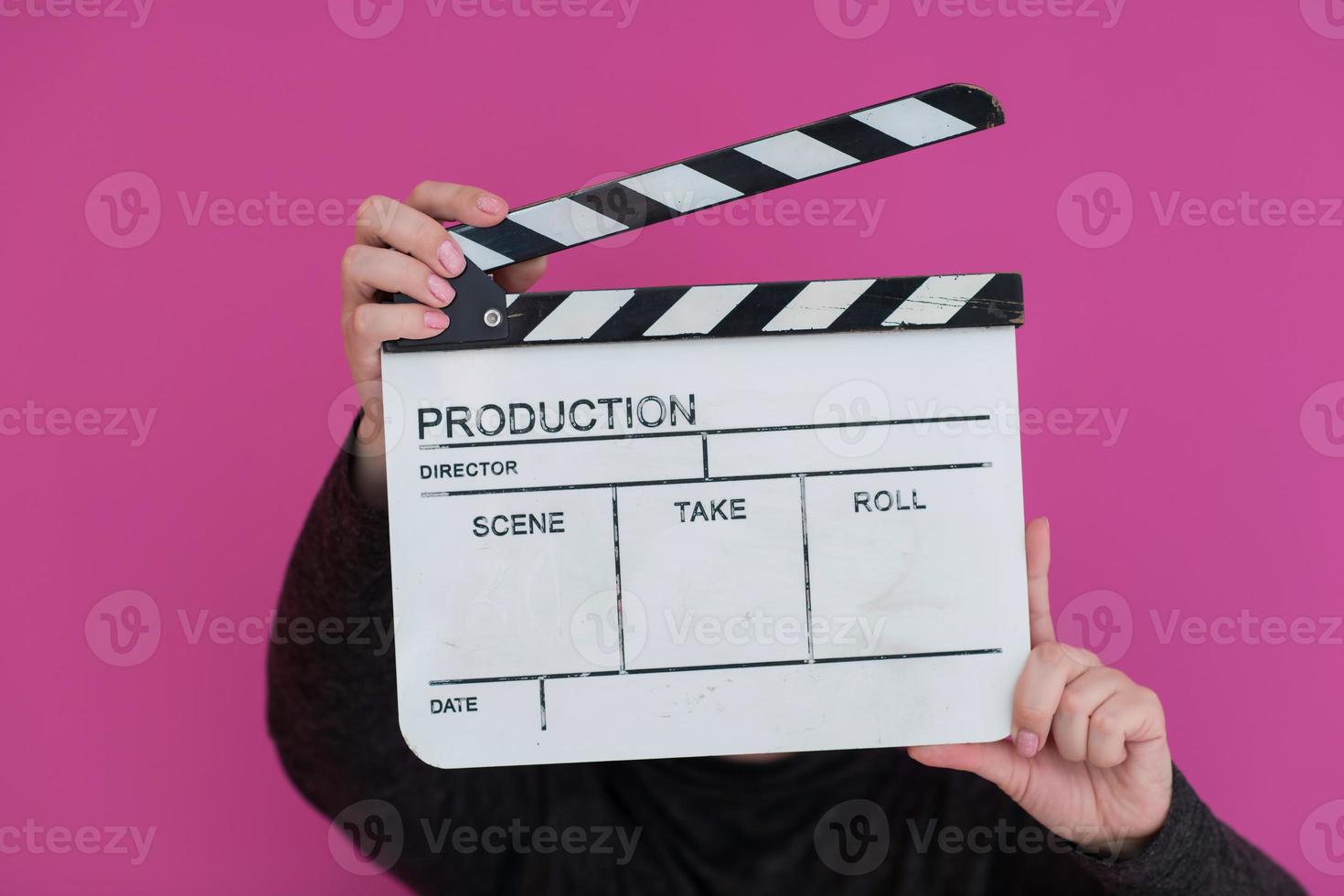 mujer pelirroja sosteniendo la chapaleta de la película sobre fondo rosa foto