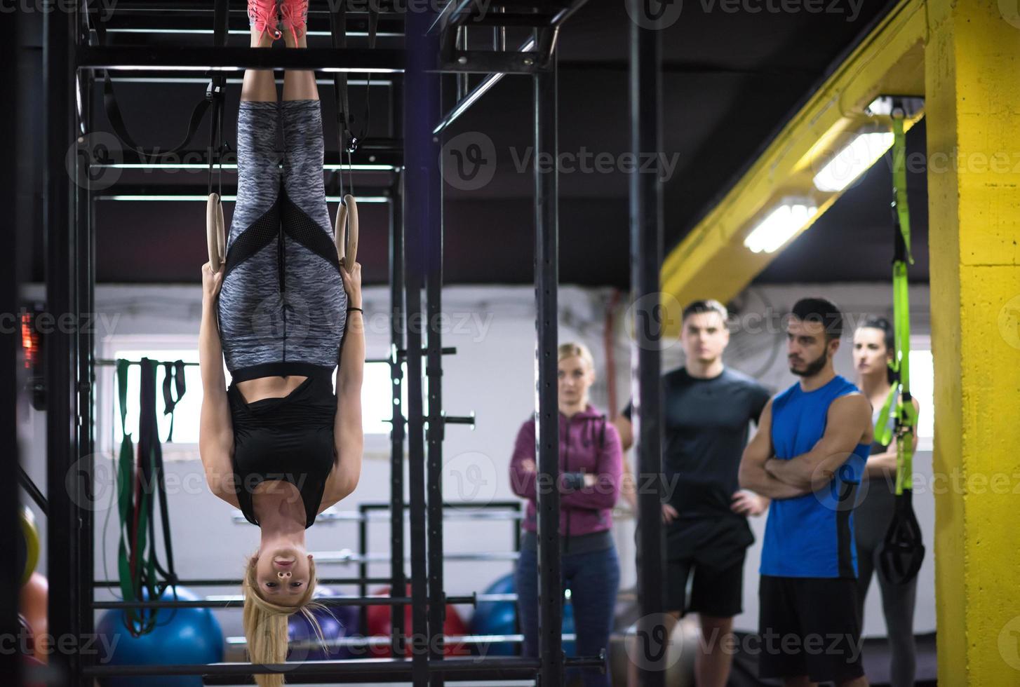 mujer trabajando con entrenador personal en anillos de gimnasia foto