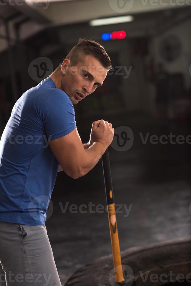 entrenamiento de hombre con martillo y neumático de tractor foto