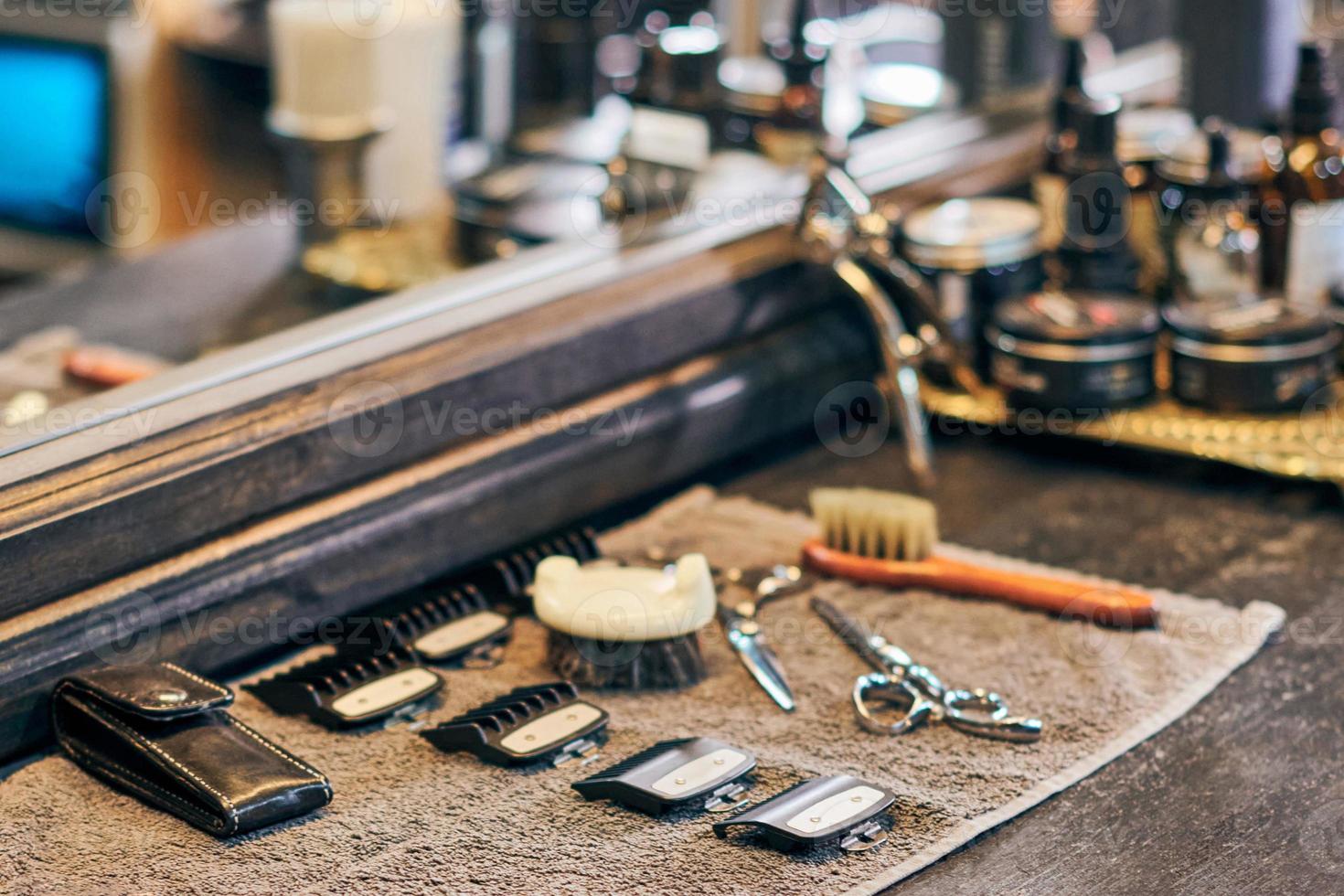 Barbershop haircut tools barber equipment on wooden countertop front of mirror, old vintage interior photo