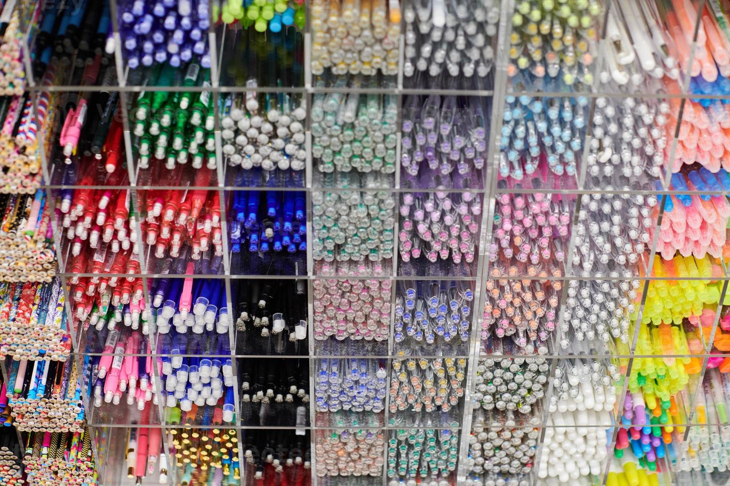 Colored pens, pencils, markers on shelf in stationery store photo