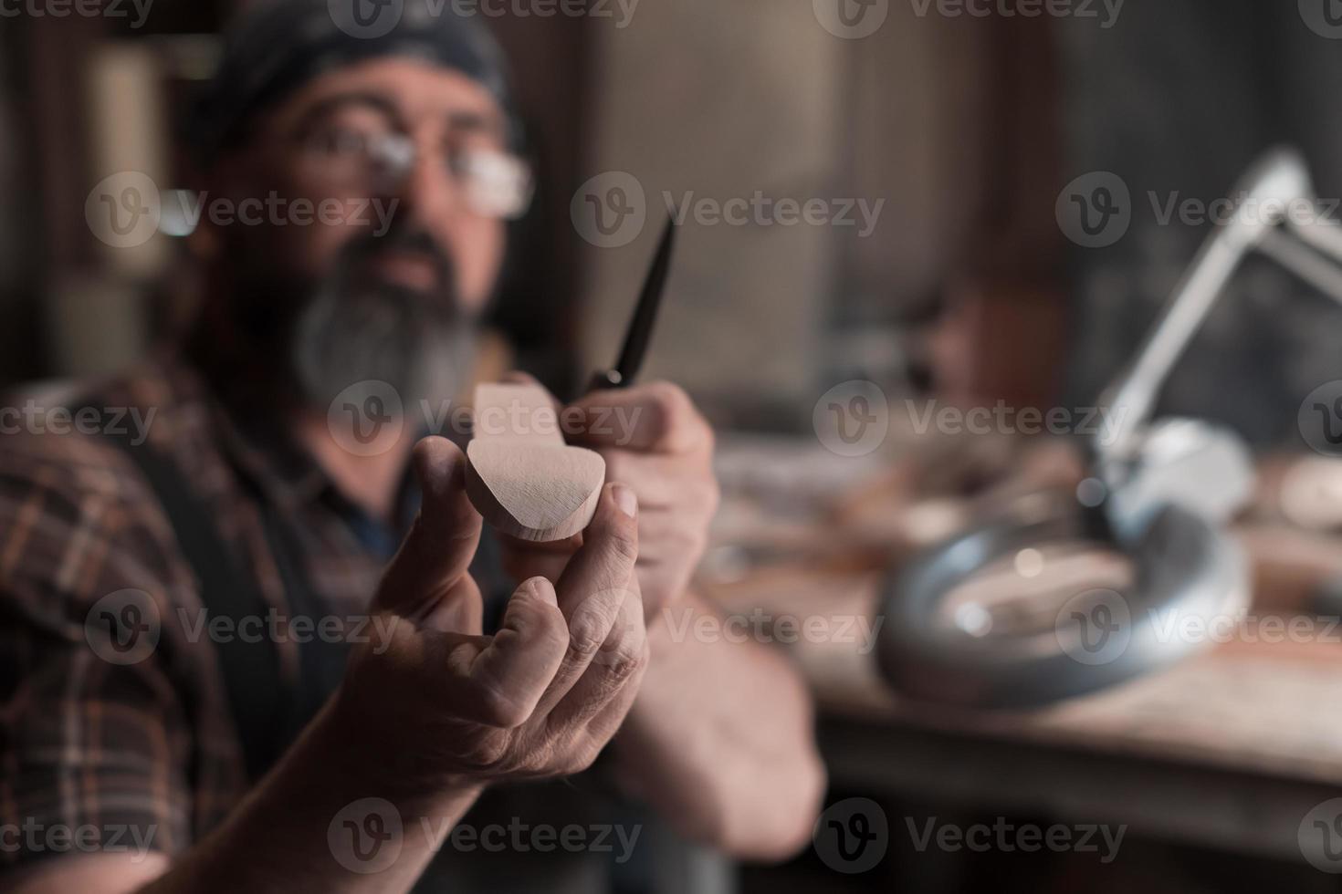 Spoon master in his workshop with wooden products and tools photo