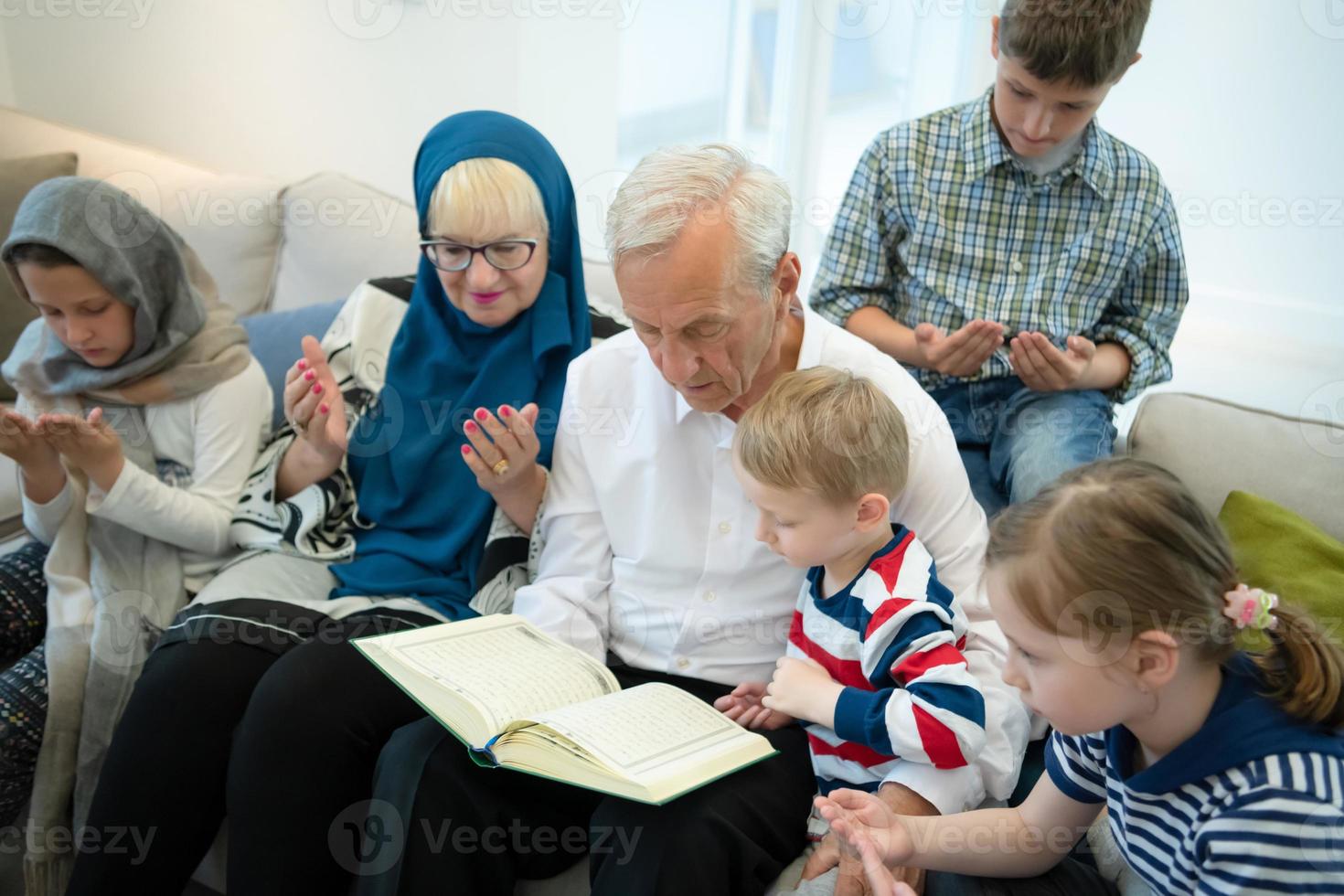 modern muslim grandparents with grandchildren reading Quran photo