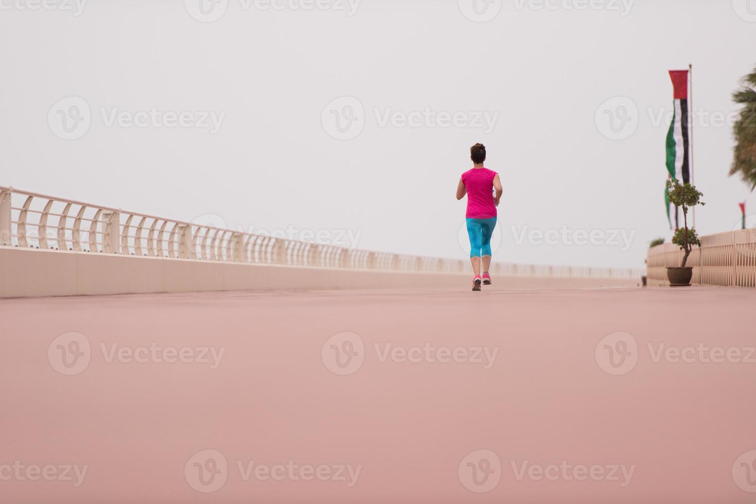 woman busy running on the promenade photo