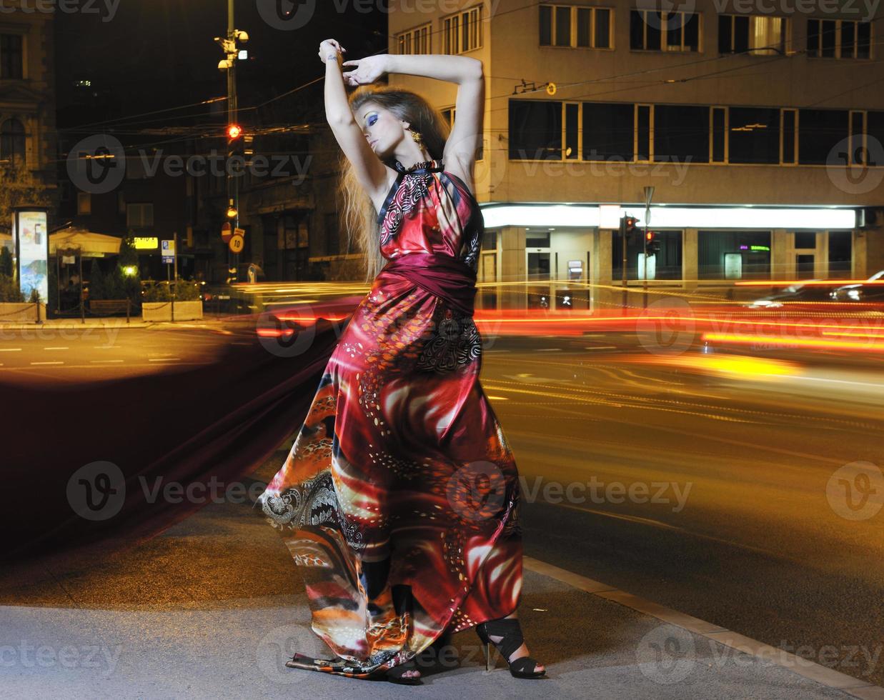 mujer elegante en la calle de la ciudad por la noche foto