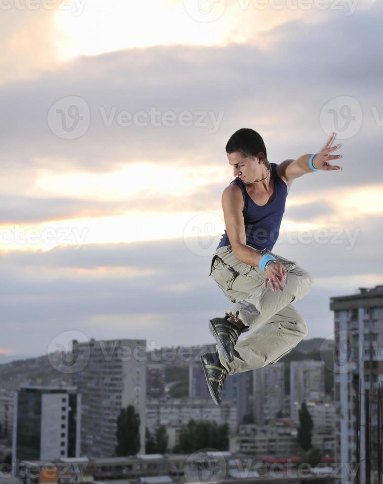 young man jumping in air outdoor at night ready for party photo