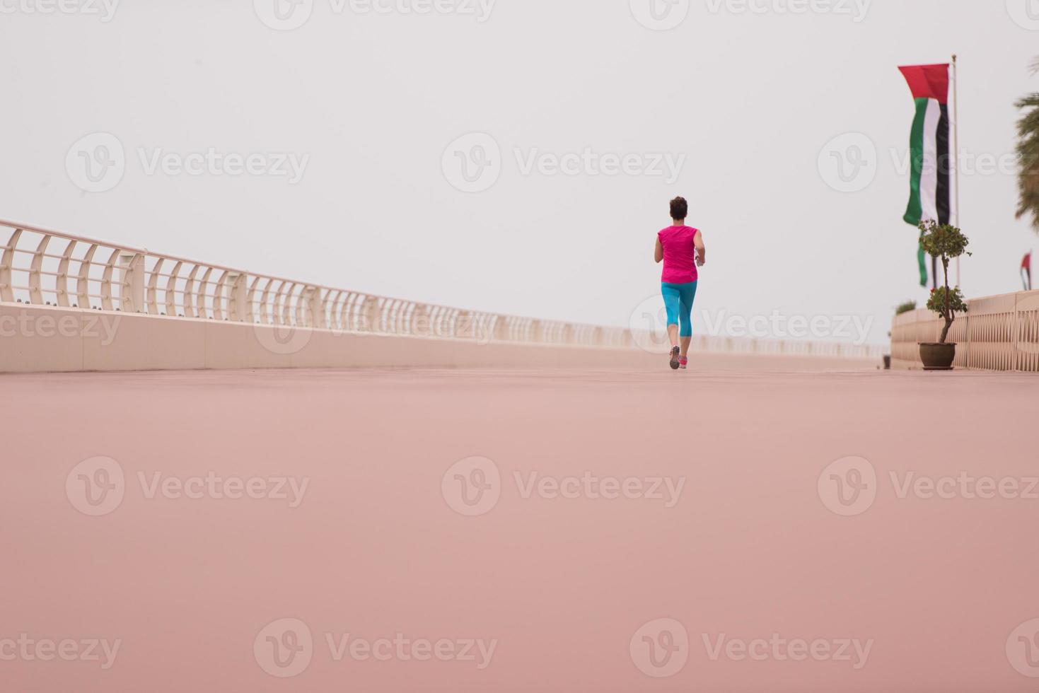 mujer ocupada corriendo en el paseo marítimo foto