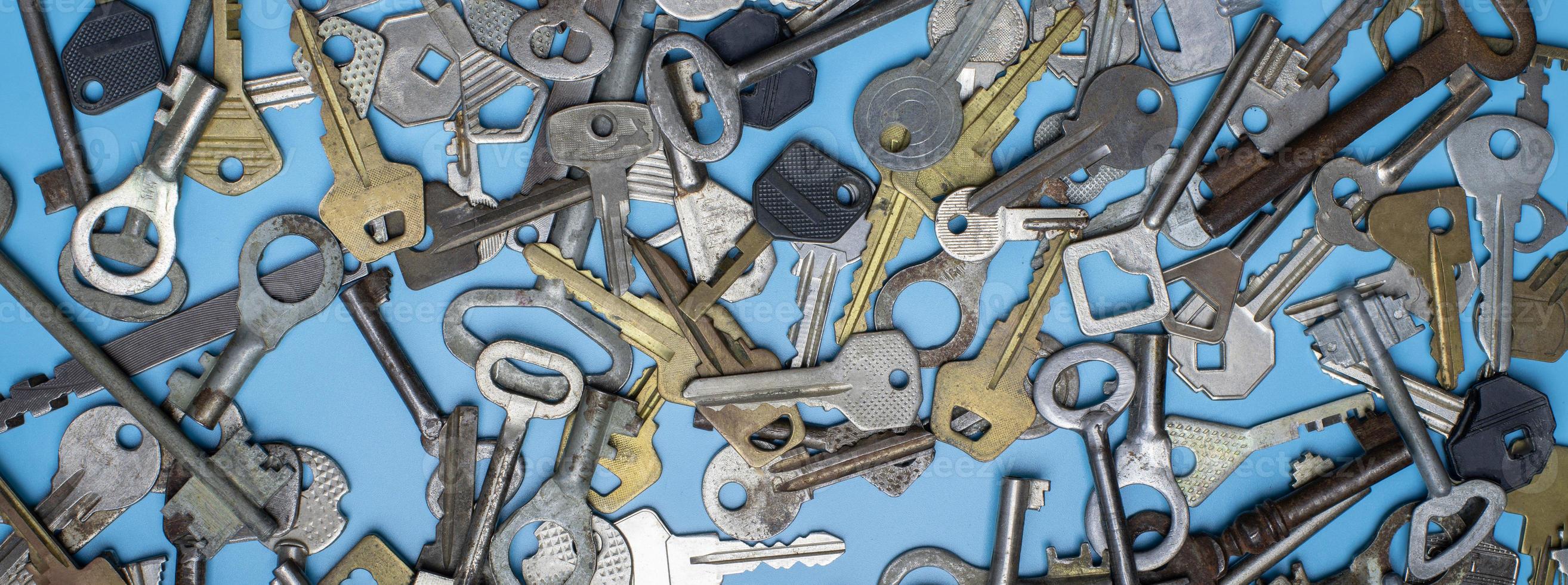 Keys set on blue background. Door lock keys and safes for property security and house protection. Different antique and new types of keys. photo