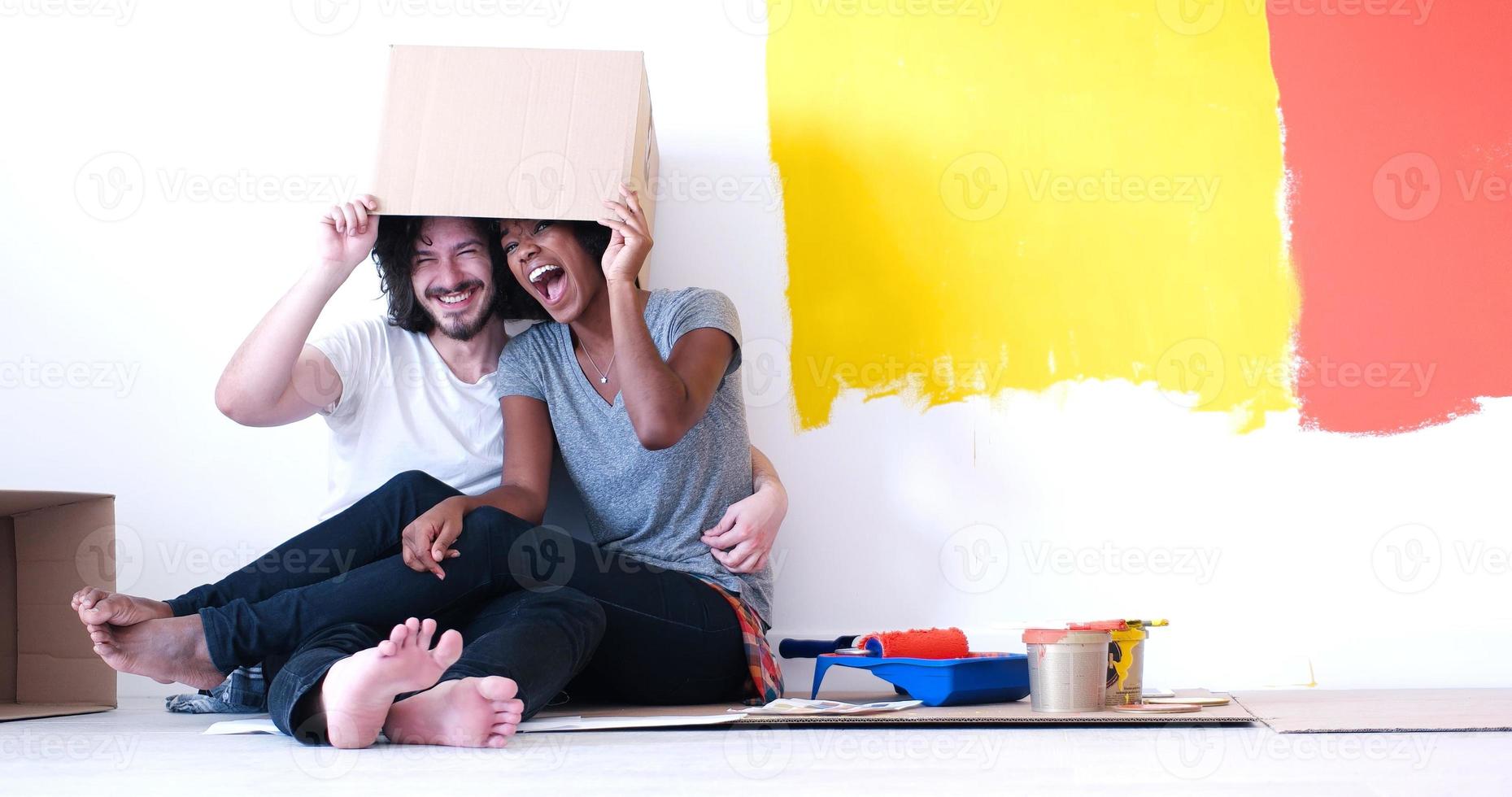 young multiethnic couple playing with cardboard boxes photo