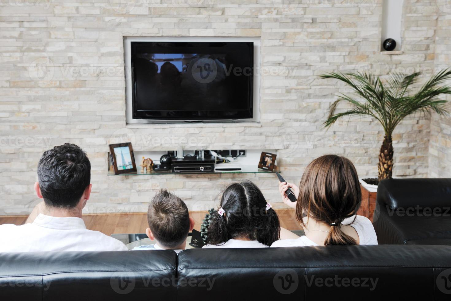 family wathching flat tv at modern home indoor photo