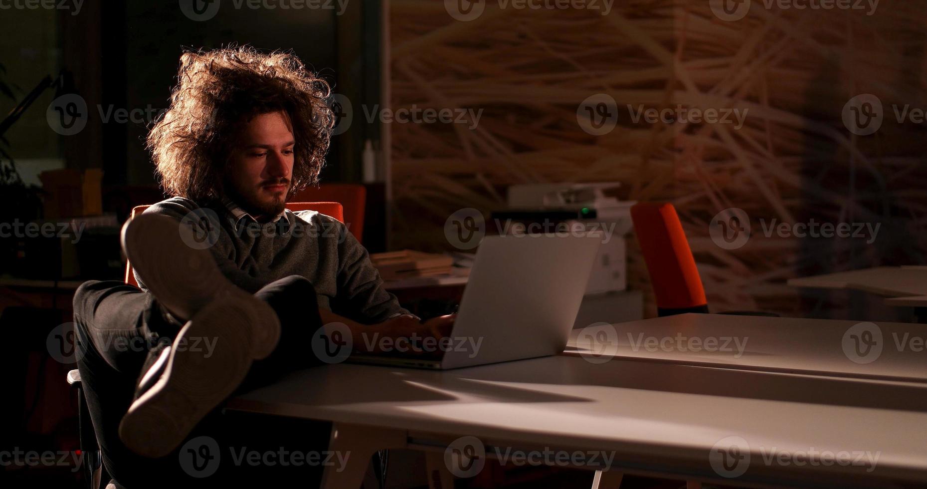 businessman sitting with legs on desk at office photo