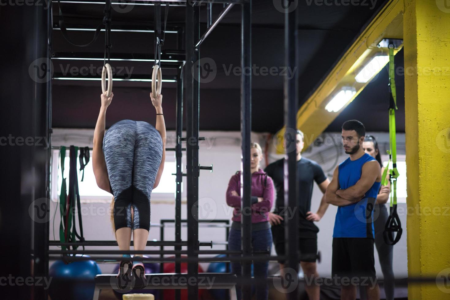 mujer trabajando con entrenador personal en anillos de gimnasia foto