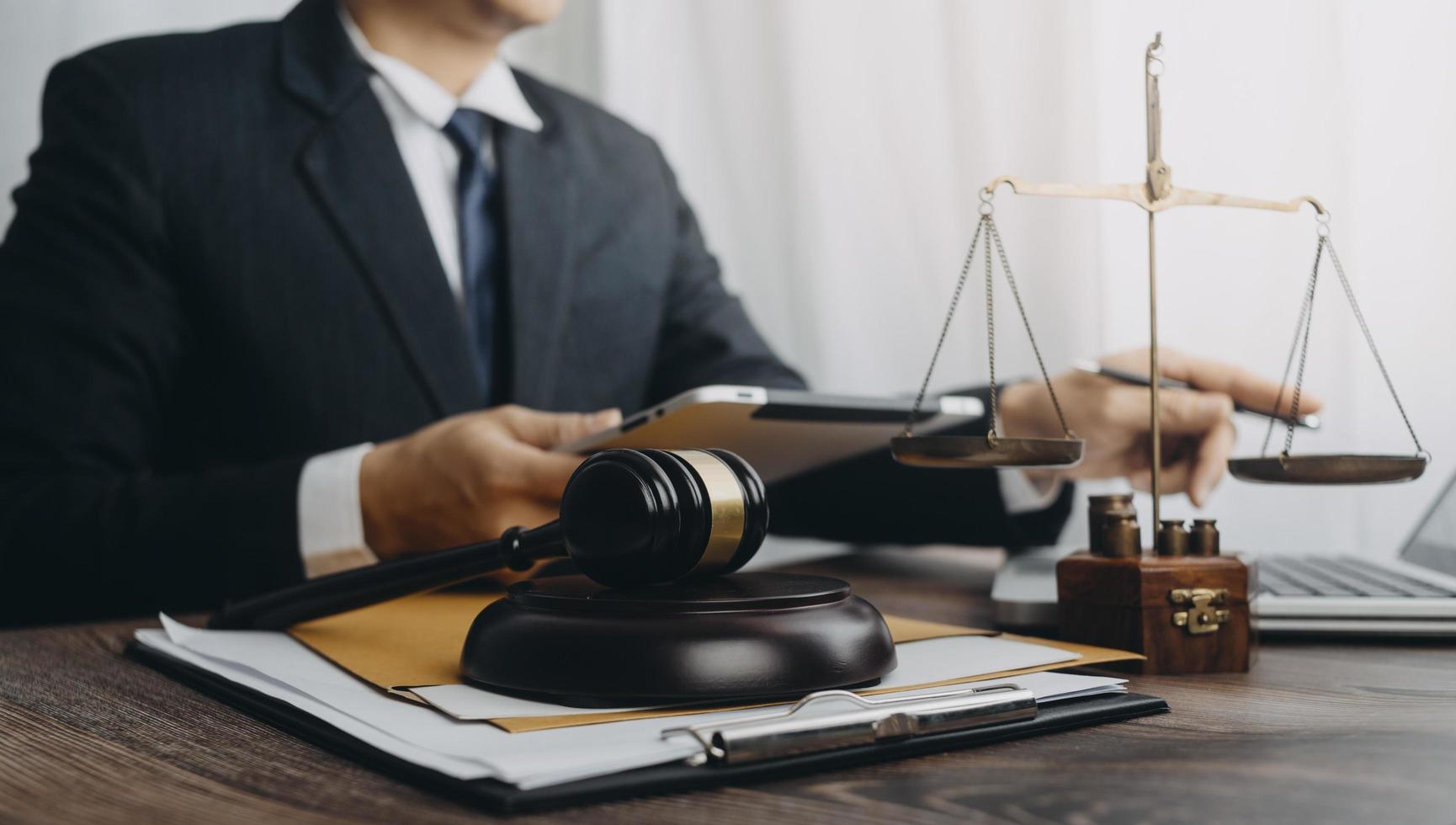 Business and lawyers discussing contract papers with brass scale on desk in office. Law, legal services, advice, justice and law concept picture with film grain effect photo