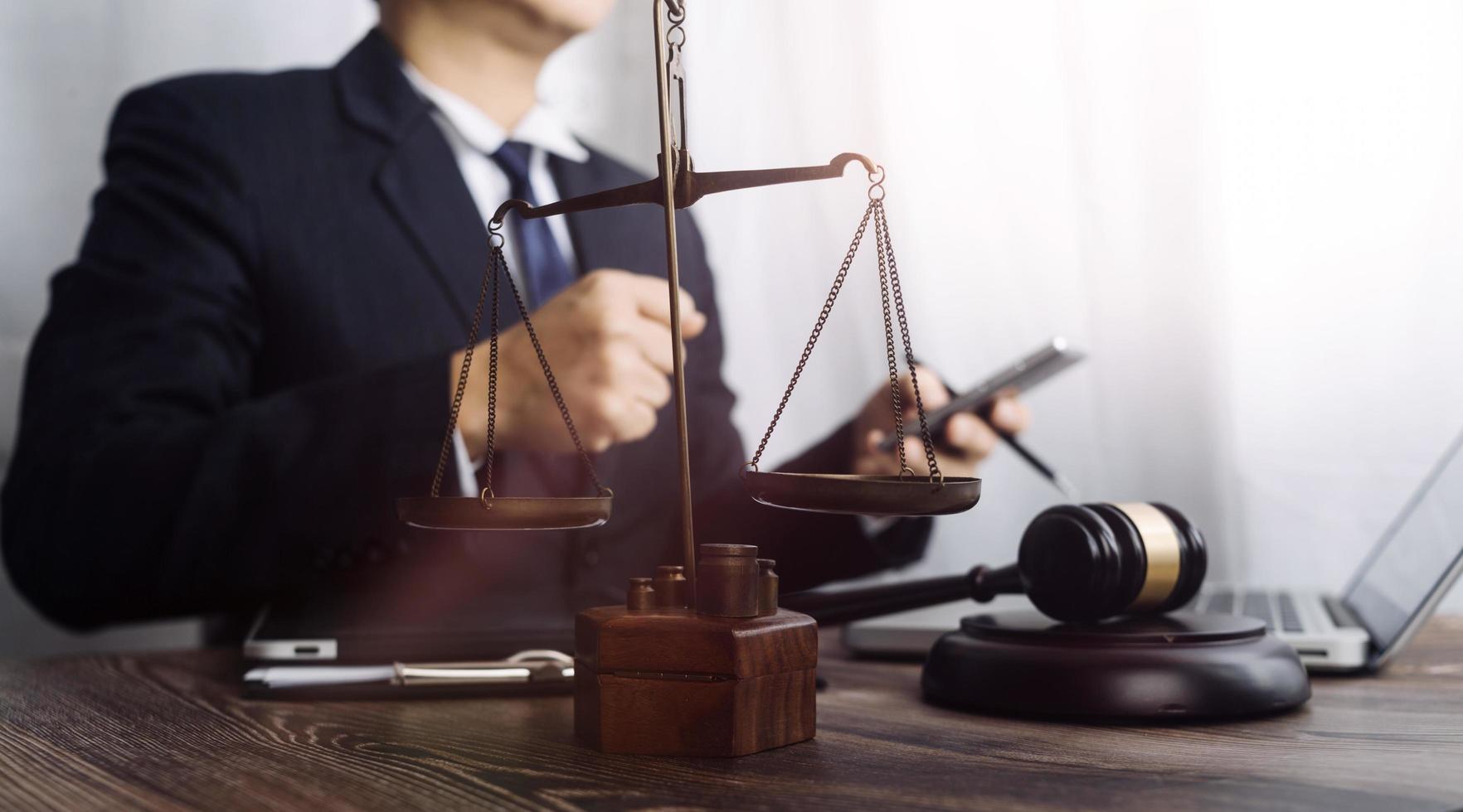 Business and lawyers discussing contract papers with brass scale on desk in office. Law, legal services, advice, justice and law concept picture with film grain effect photo