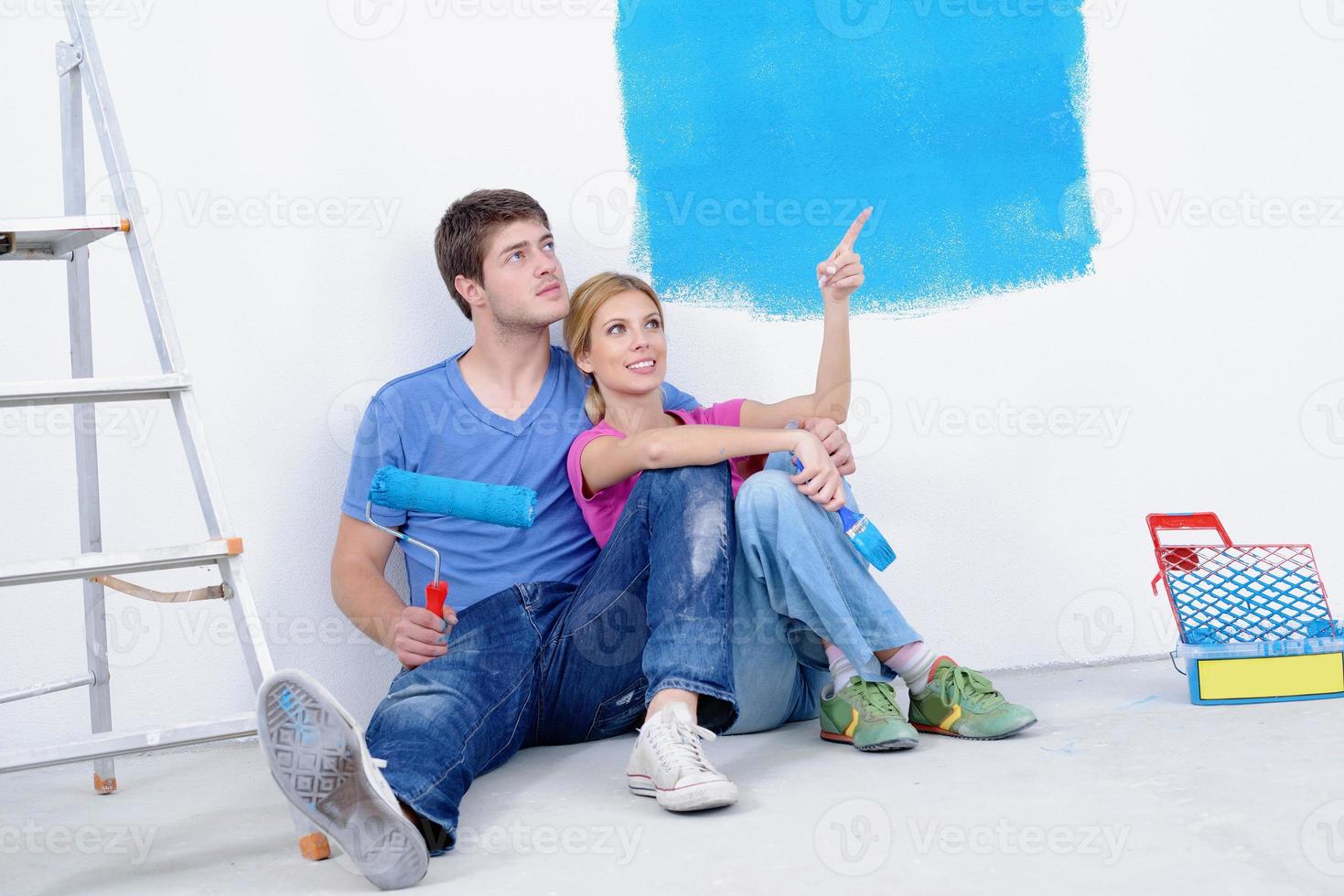 happy young cople relaxing after painting in new home photo